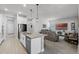 Open concept kitchen and living room featuring a large island, stainless steel appliances, and comfortable seating at 14925 Lebeau Loop, Winter Garden, FL 34787