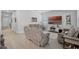 Comfortable living room featuring reclining sofa seating, modern decor, and natural light from large windows at 14925 Lebeau Loop, Winter Garden, FL 34787