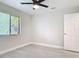 This sunny bedroom includes a window, wood-look floors, neutral paint, and a white door at 1591 Revere Ln, Daytona Beach, FL 32117