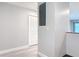 Bright hallway with light gray walls, baseboards, and wood-look flooring leads to a white door at 1591 Revere Ln, Daytona Beach, FL 32117