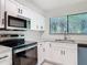 Modern kitchen with sleek countertops, a stainless steel microwave, and stylish white cabinets at 1591 Revere Ln, Daytona Beach, FL 32117