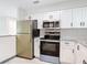 Modern kitchen featuring stainless steel appliances, white cabinets, and stylish countertops at 1591 Revere Ln, Daytona Beach, FL 32117