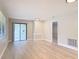 Bright living room with gray walls, baseboards, wood-look flooring, and sliding glass door at 1591 Revere Ln, Daytona Beach, FL 32117