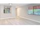 Neutral living room with wood-look flooring, window, and a pass-through to the kitchen at 1591 Revere Ln, Daytona Beach, FL 32117