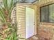 Exterior storage area featuring a convenient access door, siding and brick facade at 1591 Revere Ln, Daytona Beach, FL 32117