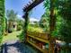 Charming backyard with a potting table under a pergola, complemented by a lush green lawn and vibrant foliage at 1791 Spruce Ave, Winter Park, FL 32789