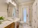 Cozy bathroom with classic fixtures, a pedestal sink, tile flooring, and a shower with floral curtain at 1791 Spruce Ave, Winter Park, FL 32789