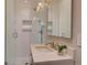 Bathroom with tiled shower, marble vanity, and decorative mirror at 1791 Spruce Ave, Winter Park, FL 32789