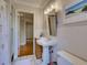 Charming bathroom featuring a pedestal sink, classic tile, and decorative accents with hall view at 1791 Spruce Ave, Winter Park, FL 32789