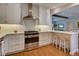 Well-equipped kitchen featuring white cabinets, stainless steel appliances, and an eat-in bar area at 1791 Spruce Ave, Winter Park, FL 32789