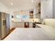 Well-lit kitchen with stainless steel refrigerator, white cabinets, and large white countertop island at 1791 Spruce Ave, Winter Park, FL 32789