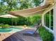 Inviting pool area featuring a wooden deck, awning, lounge chairs, and lush landscaping for relaxed outdoor living at 1791 Spruce Ave, Winter Park, FL 32789