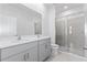Modern bathroom featuring a double sink vanity, glass shower enclosure, and gray cabinetry at 2026 Firethorn Loop, Haines City, FL 33844