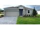 Charming single-story home featuring a gray exterior, manicured lawn, and a convenient two-car garage at 2026 Firethorn Loop, Haines City, FL 33844