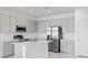 Modern kitchen featuring stainless steel appliances, gray cabinets, quartz countertops, and a central island at 2026 Firethorn Loop, Haines City, FL 33844