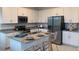 Modern kitchen with stainless steel appliances, granite countertops, island seating, and ample cabinet space at 2026 Firethorn Loop, Haines City, FL 33844