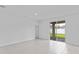 Expansive living room featuring neutral tile flooring, white walls, and sliding glass doors to the exterior at 2026 Firethorn Loop, Haines City, FL 33844