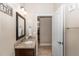 Granite vanity area offers a framed mirror, vanity lighting, and doorway to the hallway at 20723 Macon Pkwy, Orlando, FL 32833