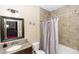 Tiled bathroom with a granite-topped vanity, framed mirror, and shower-tub combination at 20723 Macon Pkwy, Orlando, FL 32833