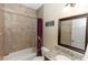 Featuring a shower-tub combo, this tiled bathroom also offers granite countertops and bright lighting at 20723 Macon Pkwy, Orlando, FL 32833