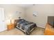 Neutral bedroom with a plaid bedspread, dresser, and bedside table at 20723 Macon Pkwy, Orlando, FL 32833