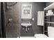 A modern bathroom features a sleek vessel sink, contemporary fixtures, and dark wall tiles to enhance the design at 2223 Amherst Ave, Orlando, FL 32804