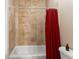 Simple bathroom featuring tiled walls, a bath, and shower at 2223 Amherst Ave, Orlando, FL 32804
