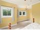 Bright bedroom with neutral carpet, large windows, yellow walls and crown molding at 2223 Amherst Ave, Orlando, FL 32804
