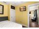Bedroom with yellow walls, a queen-size bed, and a view into the living room at 2223 Amherst Ave, Orlando, FL 32804