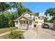 Charming yellow home with a lovely front porch, lush landscaping, and a brick driveway at 2223 Amherst Ave, Orlando, FL 32804
