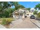 Charming two-story home with a welcoming front porch and brick driveway and lush landscaping at 2223 Amherst Ave, Orlando, FL 32804