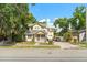 Inviting two-story home with a charming front porch, lush landscaping, and a brick driveway at 2223 Amherst Ave, Orlando, FL 32804