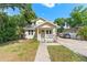A charming yellow home with lush landscaping, and a brick walkway at 2223 Amherst Ave, Orlando, FL 32804