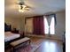 Spacious main bedroom featuring gleaming hardwood floors and decorative window coverings at 2818 Sheila Dr, Apopka, FL 32712
