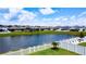 Lush backyard view overlooking a serene pond, beautifully framed by a classic white picket fence at 2943 Slough Creek Dr, Kissimmee, FL 34744