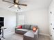 Inviting bedroom featuring a comfortable gray couch, modern ceiling fan, and bright window that fills the space with natural light at 2943 Slough Creek Dr, Kissimmee, FL 34744