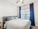 Cozy bedroom featuring a stylish gray bed, modern ceiling fan, and a large window, providing a serene and relaxing space at 2943 Slough Creek Dr, Kissimmee, FL 34744