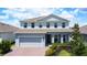 Charming two-story home featuring a two-car garage, well-manicured landscaping, and a welcoming front porch at 2943 Slough Creek Dr, Kissimmee, FL 34744