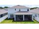 Back exterior view of a two-story home featuring a screened lanai and well-maintained lawn at 2943 Slough Creek Dr, Kissimmee, FL 34744