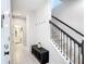 Inviting hallway with staircase, neutral paint, and tile flooring that leads to an adjacent bathroom at 2943 Slough Creek Dr, Kissimmee, FL 34744