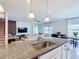 Open-concept kitchen with granite countertops, stainless steel sink, and adjacent dining and living spaces at 2943 Slough Creek Dr, Kissimmee, FL 34744