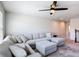 Comfortable living room with a large sectional sofa, ceiling fan, and neutral color palette at 2943 Slough Creek Dr, Kissimmee, FL 34744