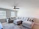 Spacious living room featuring a large sectional sofa, modern ceiling fan, and neutral decor at 2943 Slough Creek Dr, Kissimmee, FL 34744