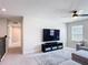 Cozy living room features a plush gray sofa, ceiling fan, and a large flat screen TV at 2943 Slough Creek Dr, Kissimmee, FL 34744