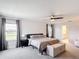 Sunlit main bedroom with a large bed, ceiling fan, and access to the en-suite bathroom at 2943 Slough Creek Dr, Kissimmee, FL 34744
