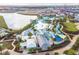 Aerial view of the resort pool, lake, commercial buildings, and residential buildings under construction at 3036 Parrot Head Pl, Kissimmee, FL 34747
