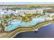 Aerial view of a resort-style pool area with many palm trees, cabanas, lounge chairs, and a lake at 3036 Parrot Head Pl, Kissimmee, FL 34747