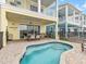 This backyard shows a splash pool and a patio area for entertaining with an outdoor grill at 3036 Parrot Head Pl, Kissimmee, FL 34747