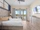 Bright, spacious bedroom featuring a luxurious upholstered headboard, wood-look tile flooring and a view of the lake at 3036 Parrot Head Pl, Kissimmee, FL 34747
