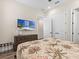 Bedroom with a queen bed and palm tree bedding, dresser with television, and double closet at 3036 Parrot Head Pl, Kissimmee, FL 34747
